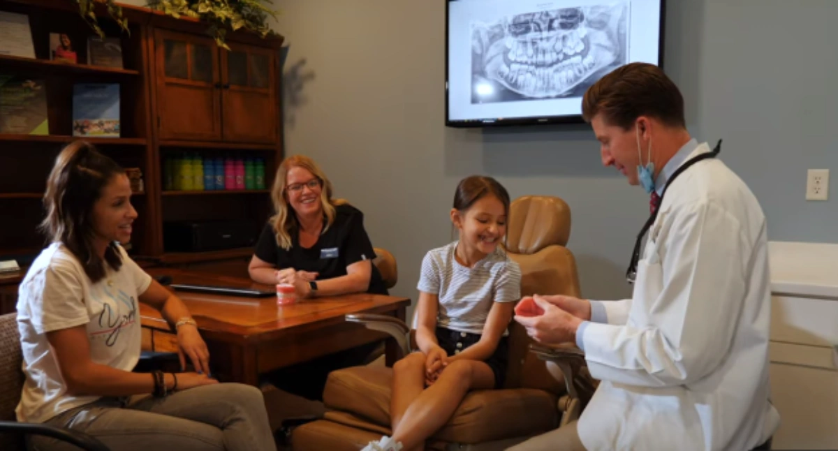 McDonough orthodontist discussing treatment with a young patient and her mother during an orthodontic consultation.